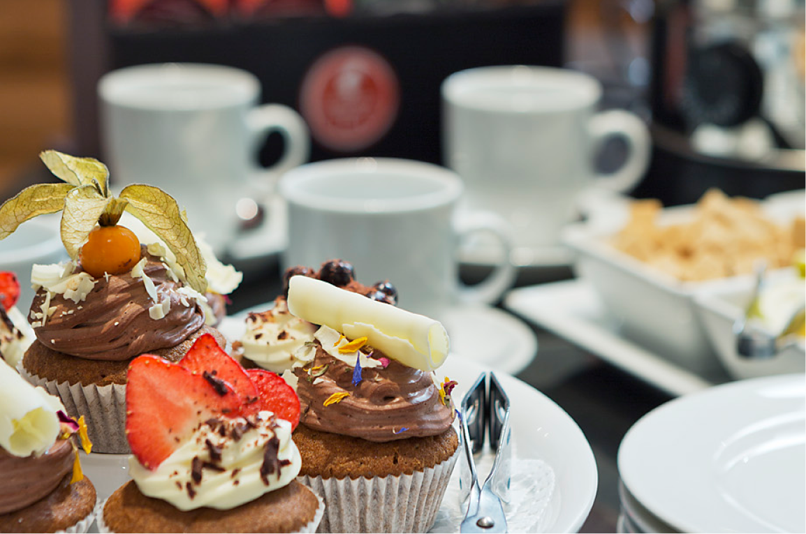 Angerichtetes Kuchenbuffet im Seminarhotel Wien mit Cupcakes und Kaffee