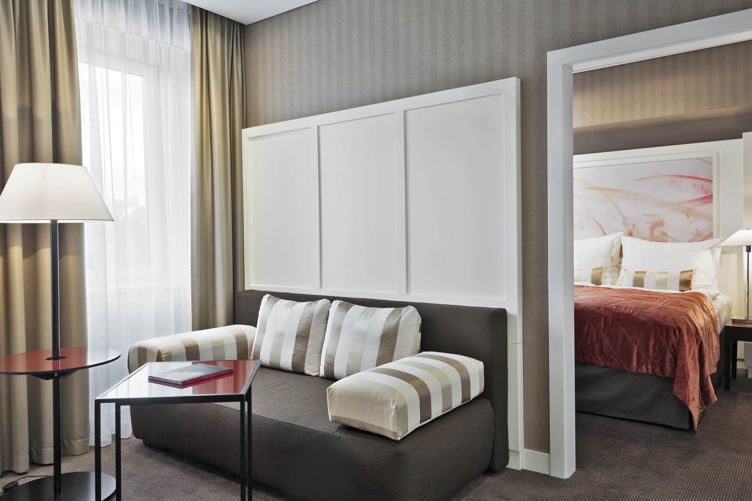 Blick auf ein Sofa mit Beistelltisch und ein Doppelbett in einem Zimmer in Wien