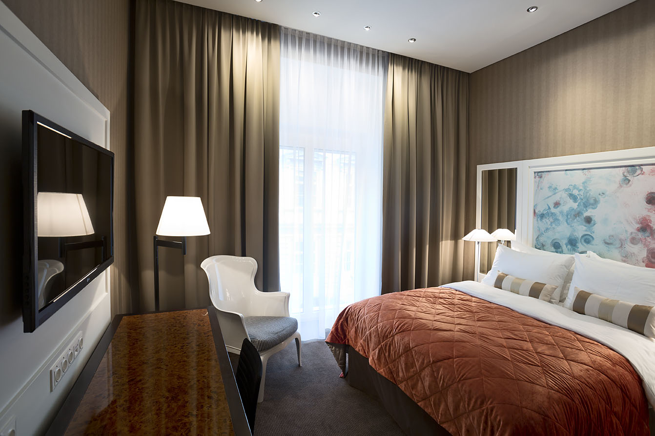 Blick in ein Doppelzimmer des Hotel Wien Zentrum mit Kommode und Doppelbett 