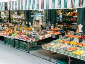 Mehrere Gemüse und Obst Kisten stehen vor einem Laden aufgereiht.